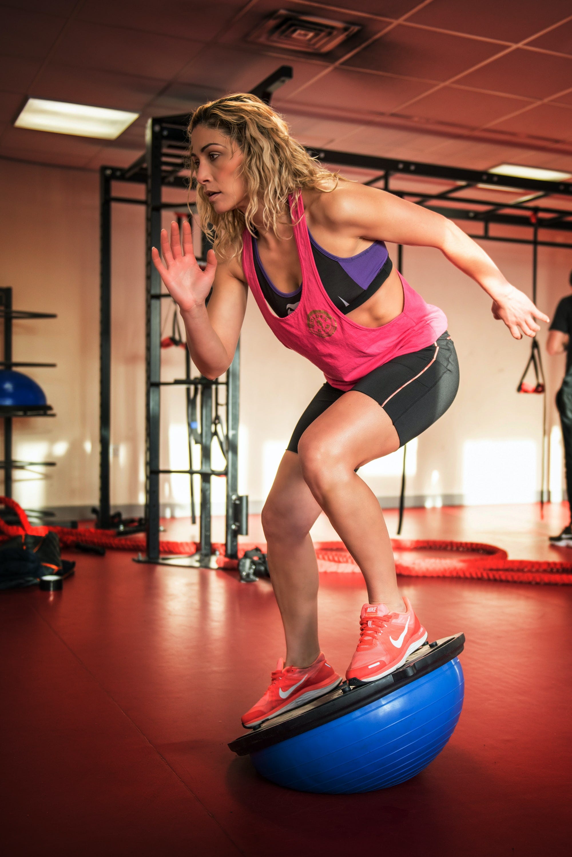 A woman exercising by balancing on half a bouncy ball 