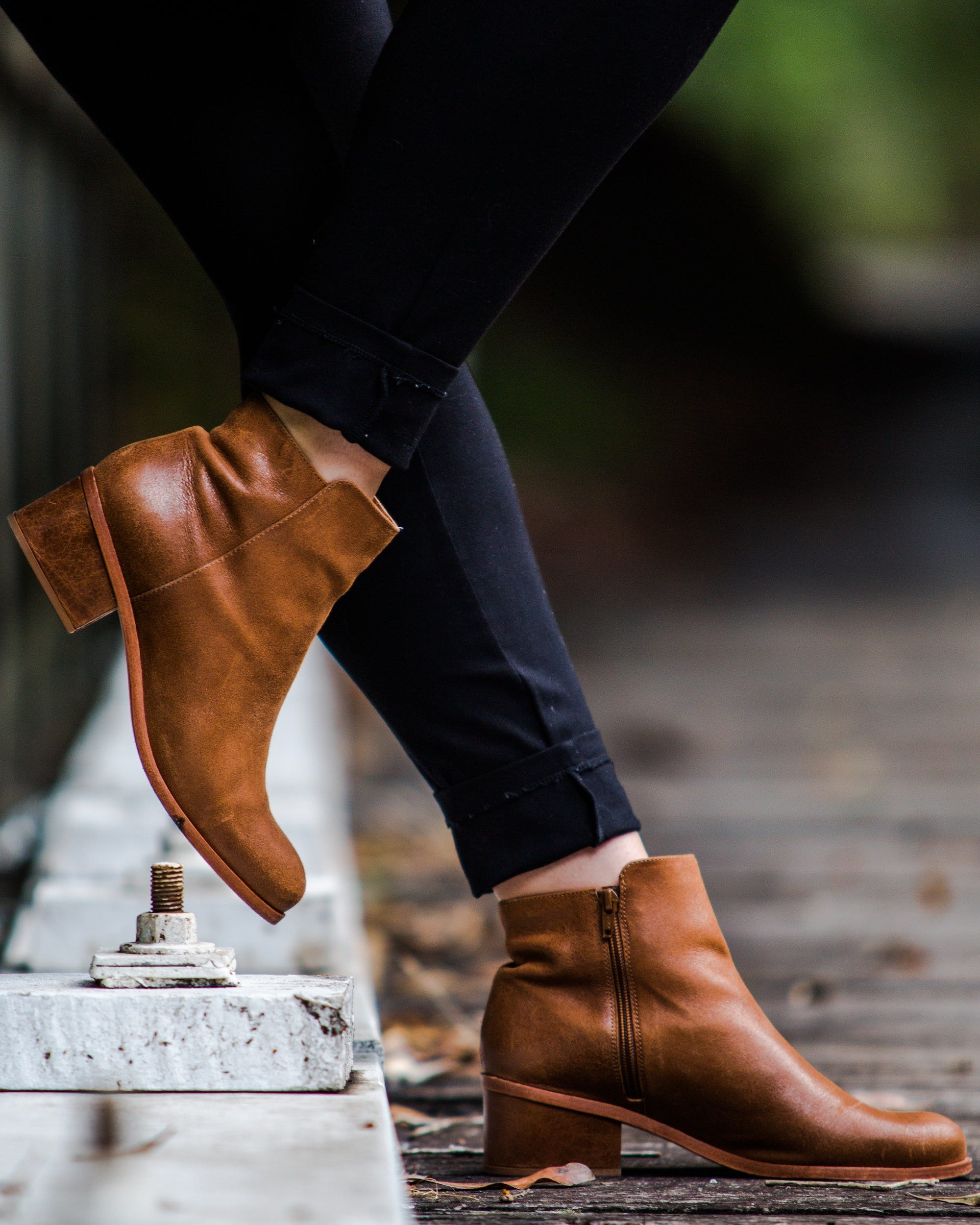 A woman wearing brown laceless boots