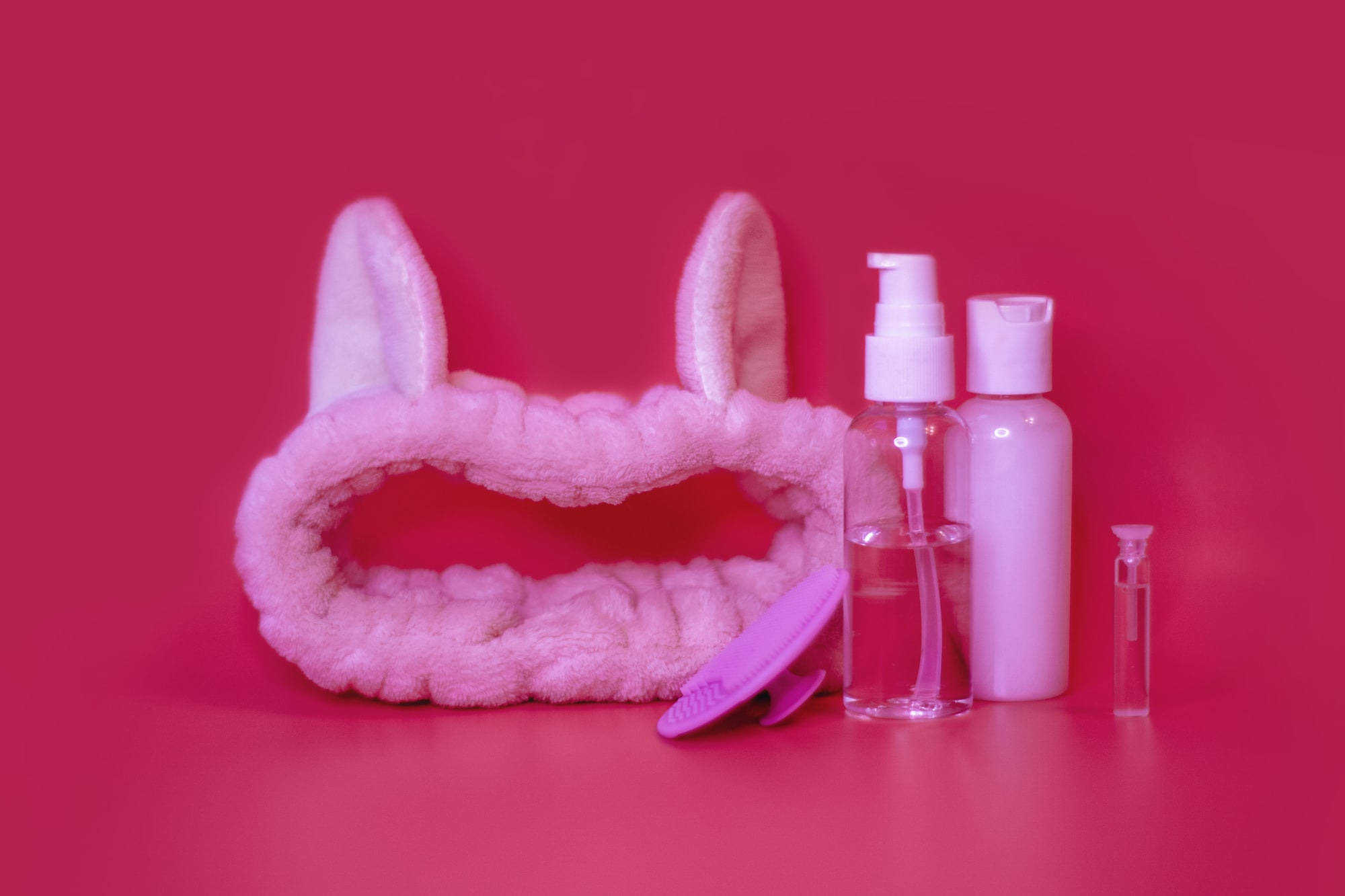 A headband with bunny ears alongside hair care products