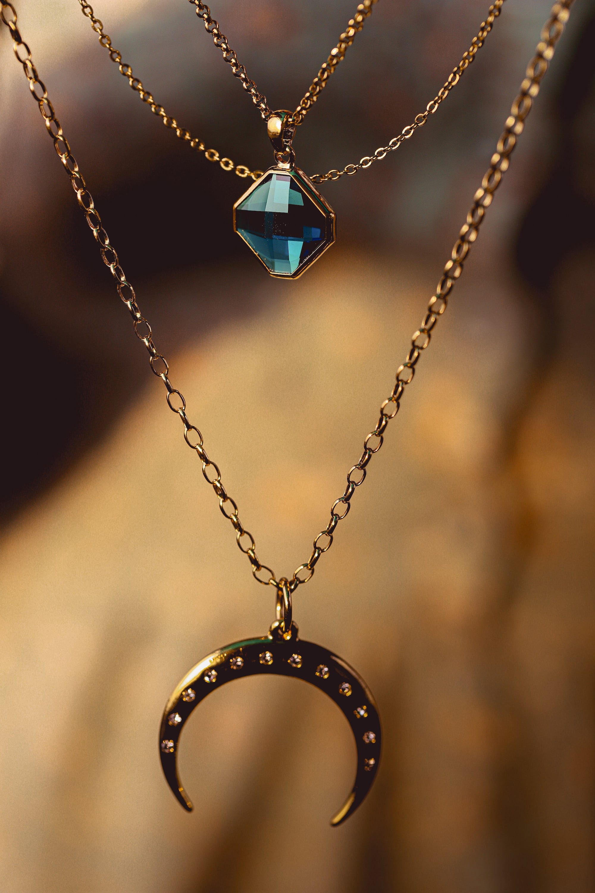 A necklace jewelry piece with a blue stone and an upside down crescent moon