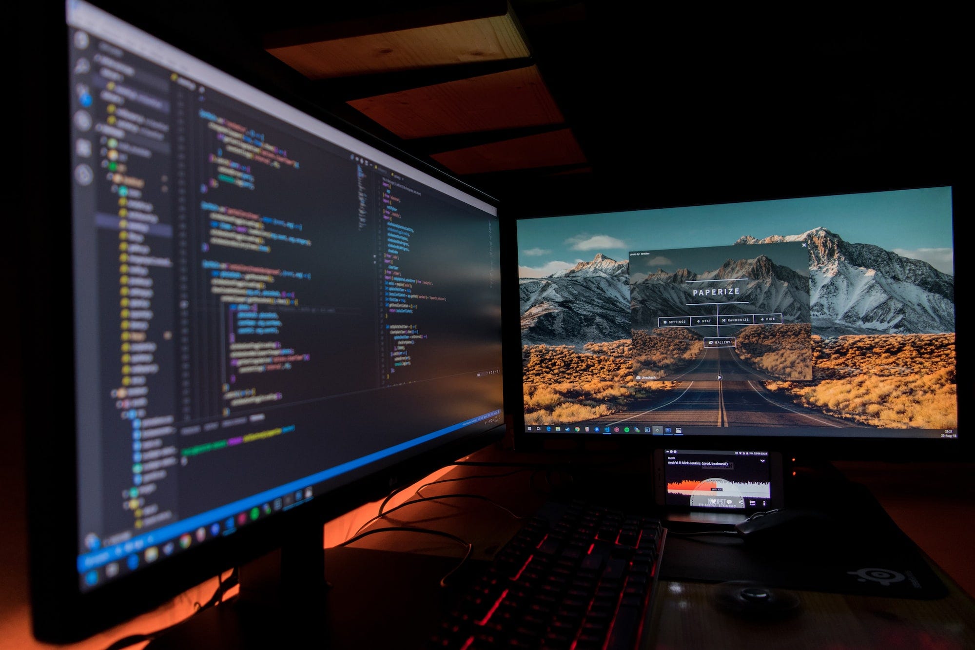 An image of two computer screens open in a 90-degree angle with a keyboard and a mouse for operating them