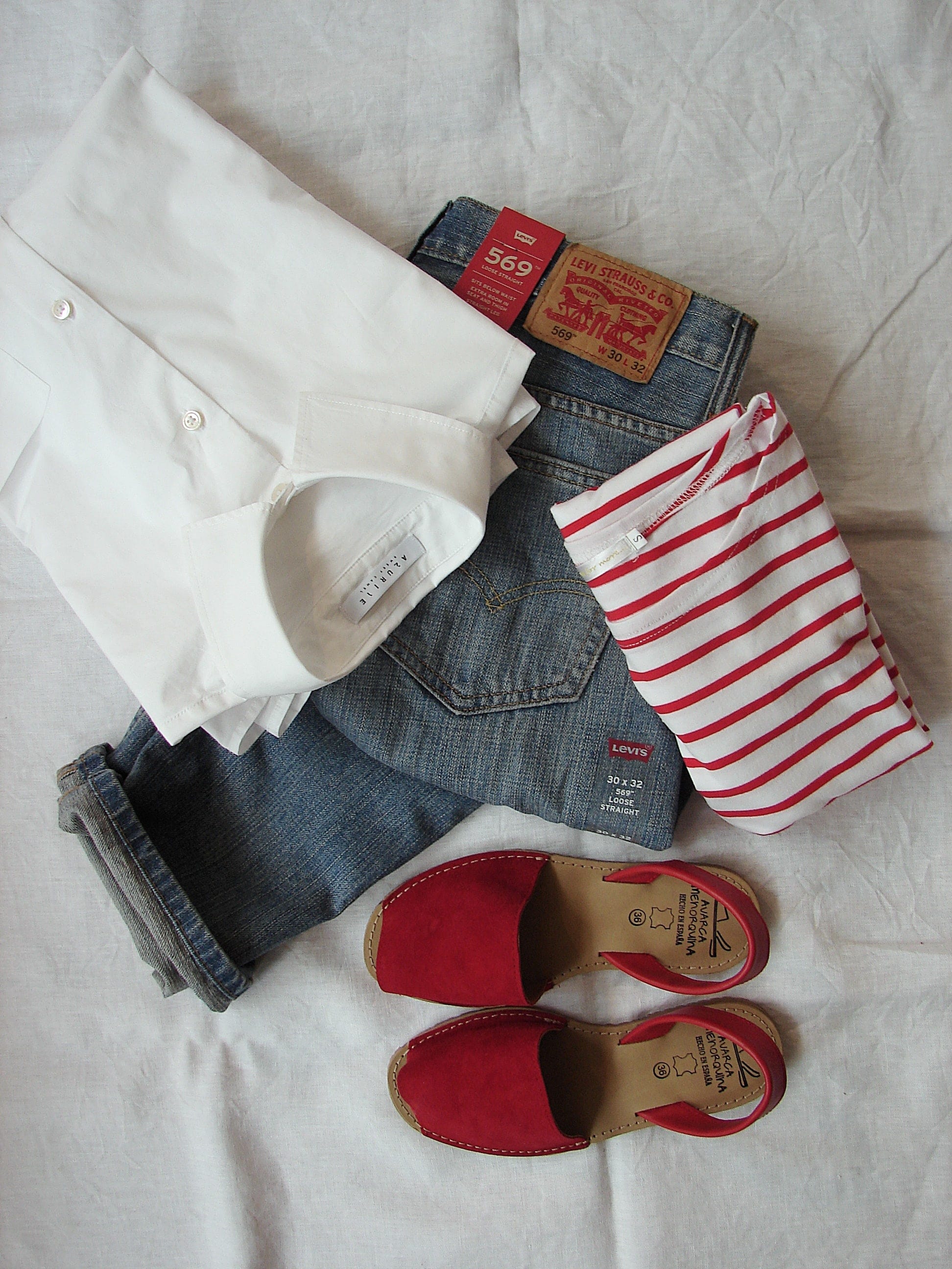 An outfit for ladies including a shirt, top, pair of jeans, and shoes