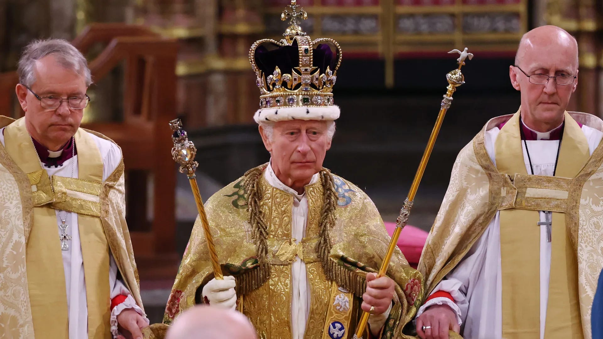 King Charles III holding the instruments of power at his coronation