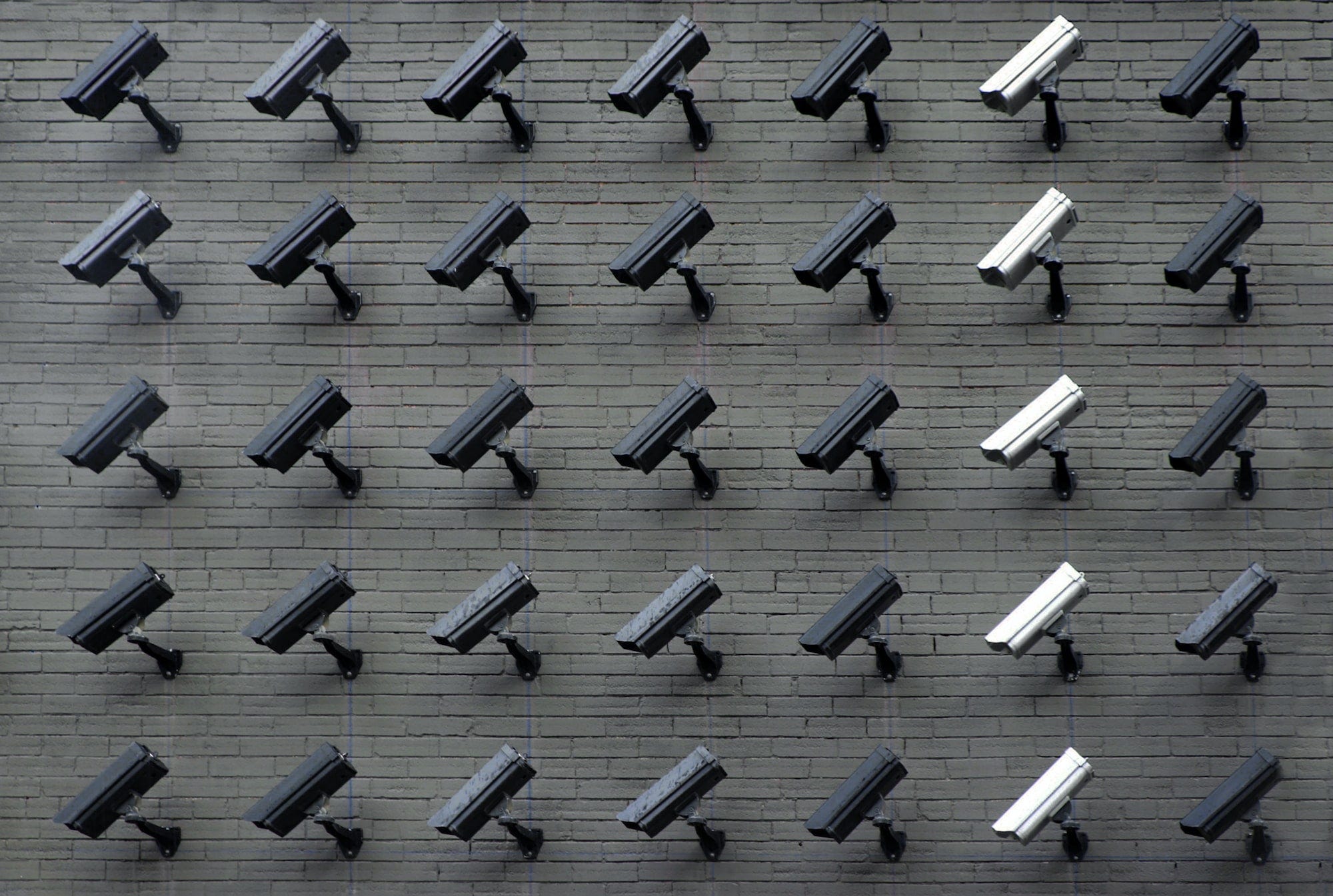 An image of multiple CCTV cameras on a wall signifying surveilance