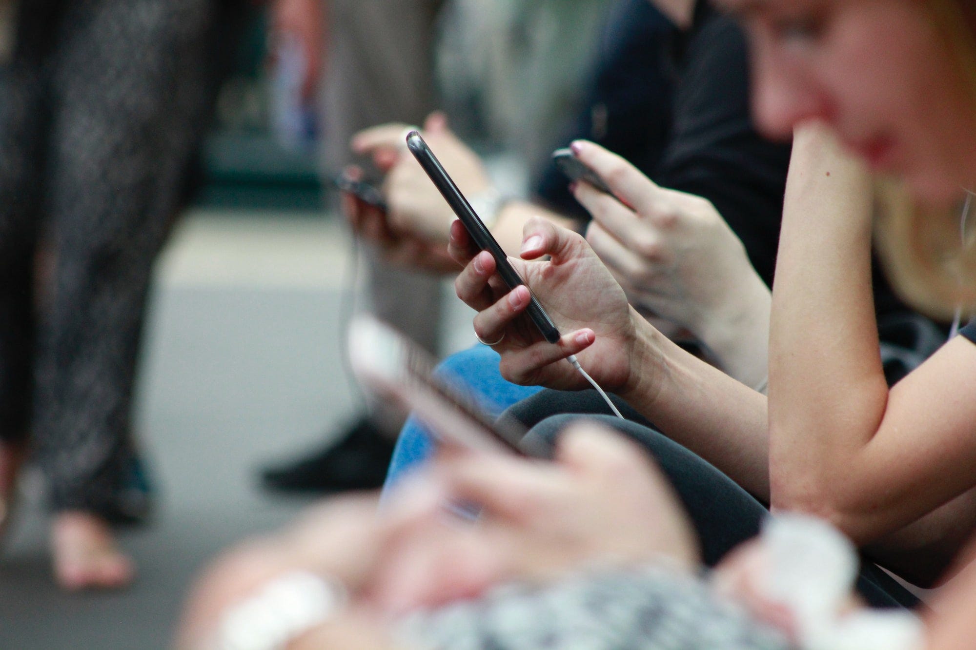 A group of people each on their phones scrolling