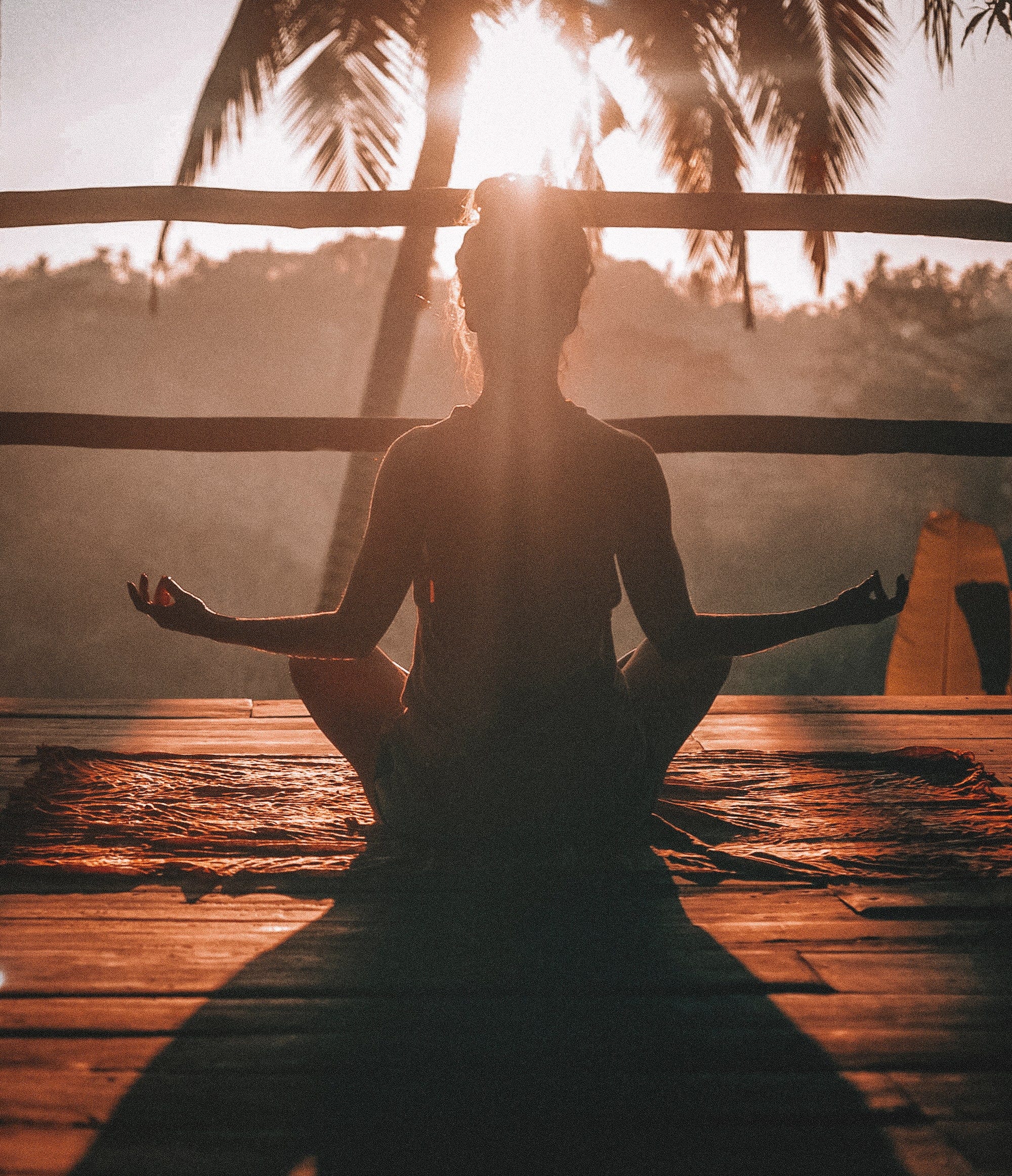 A woman undertaking a morning yoga session while peering into the jungle in Ubud, Bali.