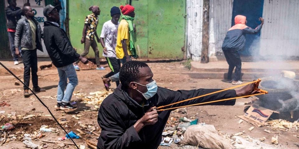 A protestor using a sling to hurl stones at Police