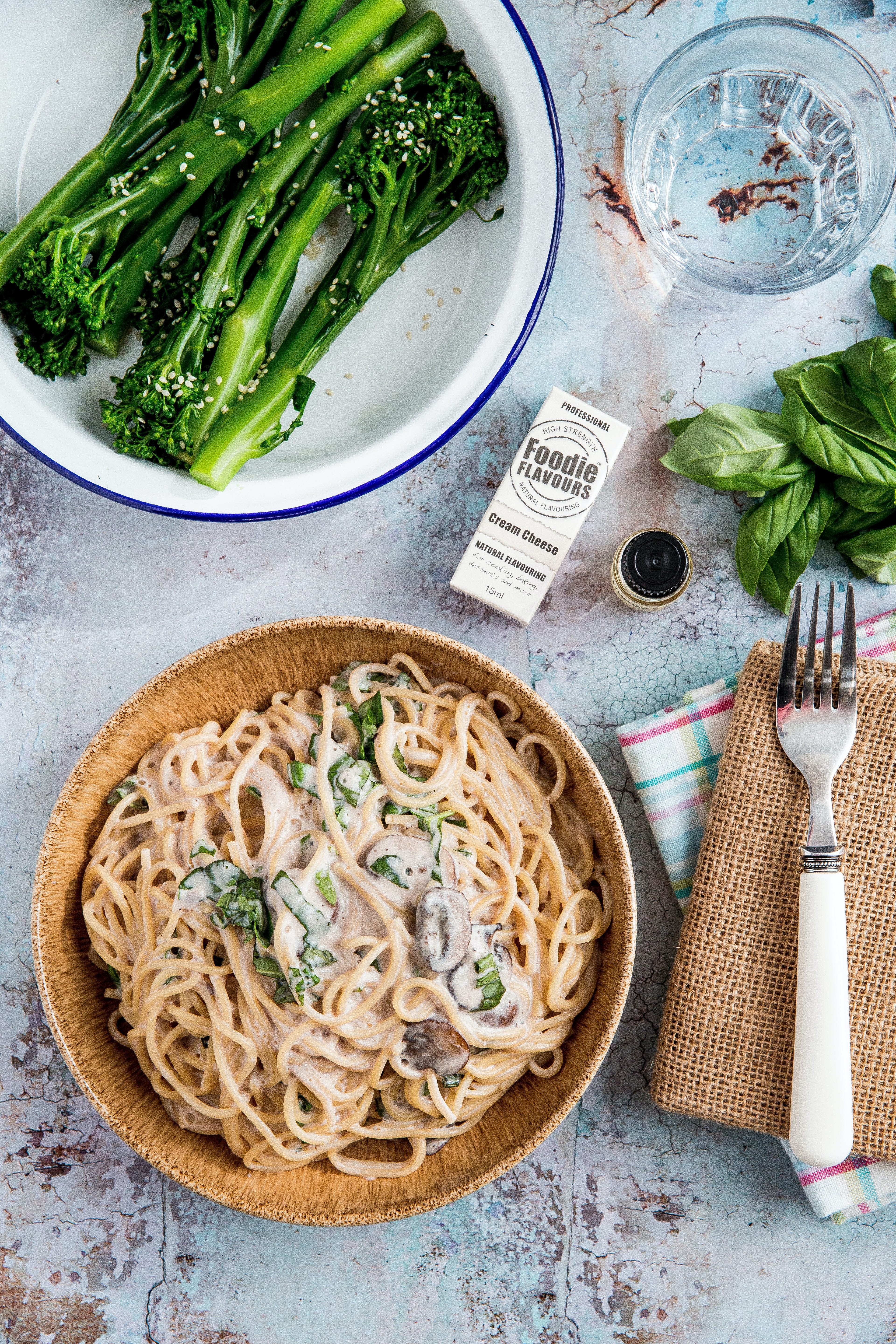 pasta in bowl near bowl of green vegetables | Why Does Spaghetti Lump Up? | Mania Lifestyle