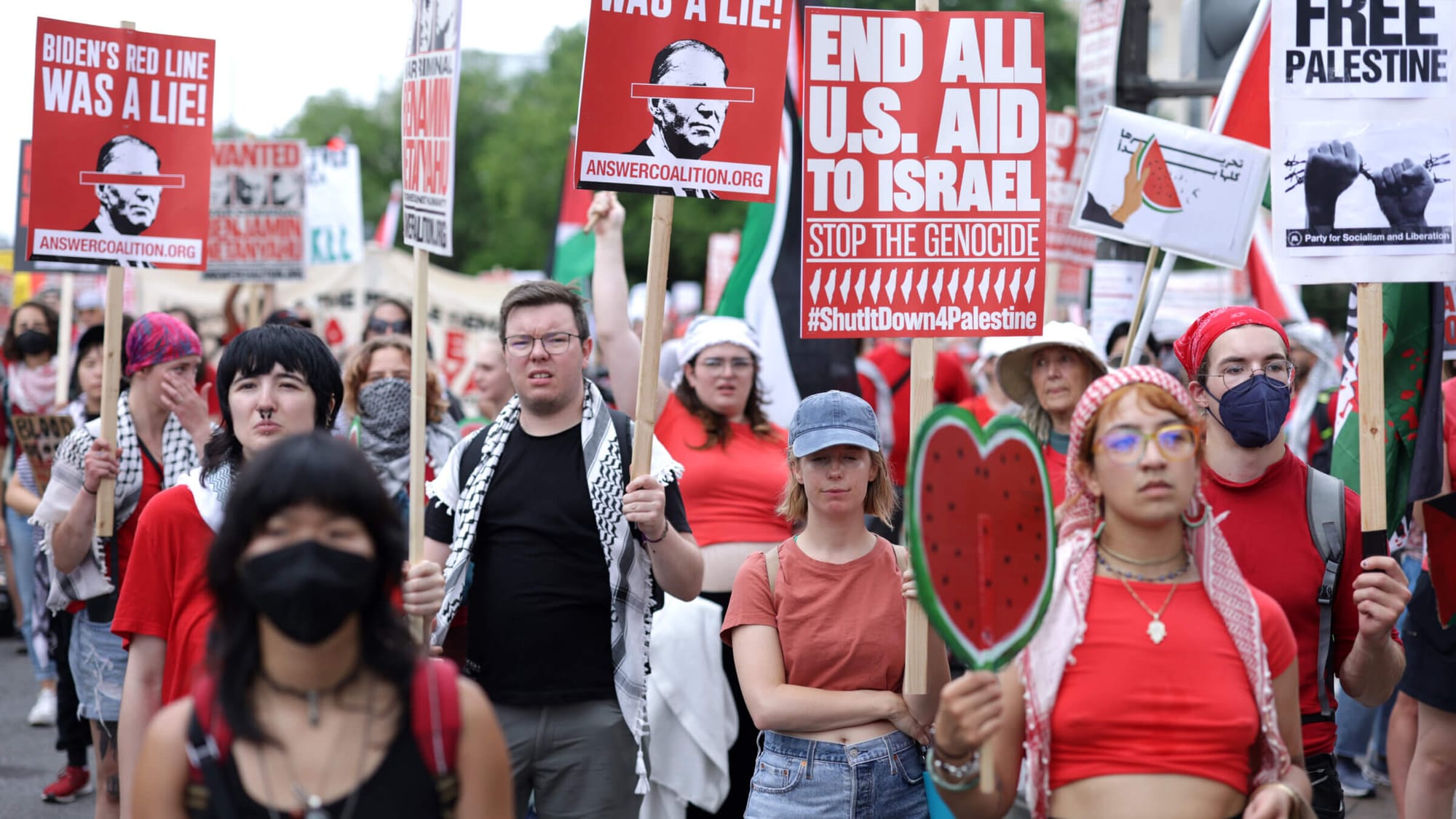 Pro-Palestine protestors carrying signs calling the Biden administration to "end all U.S aid to Israel" and another saying "Biden's red line was a lie!" | DNC protests | Mania News