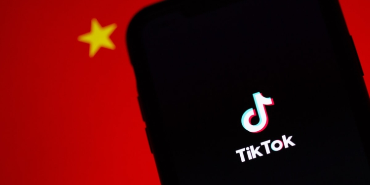 A TikTok app on a phone infront of the Chinese flag